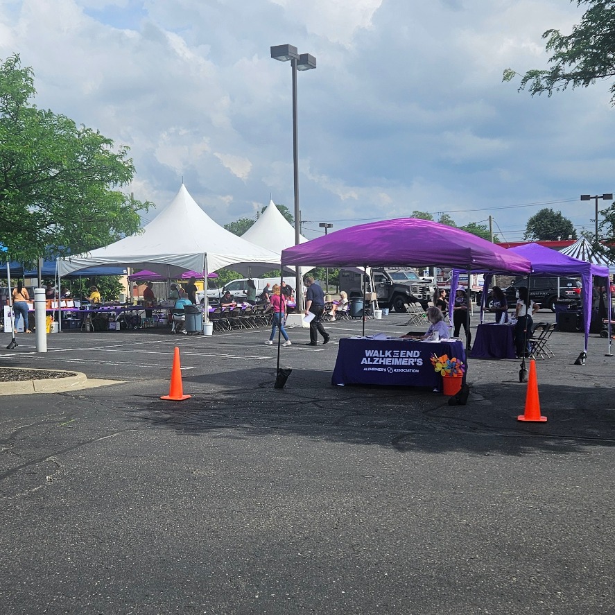 Walk to End Alzheimer's — Detroit kickoff event tents and registration table in a sunny Southeast Michigan parking lot